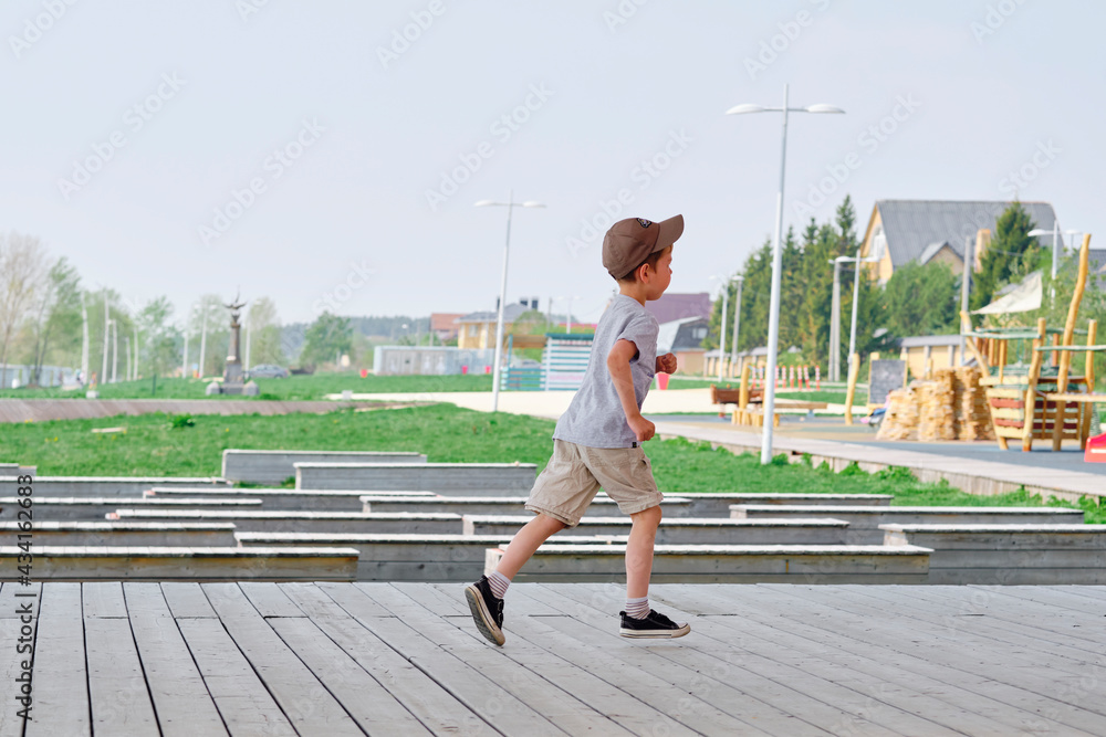 boy runs on the veranda in the street. Happy and active childhood of the child