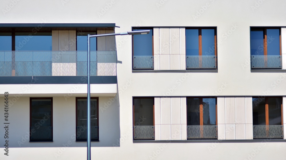 Condominium and apartment building with  symmetrical modern architecture. Detail in modern residential flat apartment building exterior. Fragment of new luxury house and home complex. 