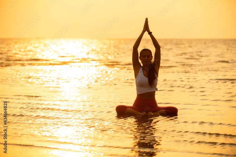Lifestyle of woman relax and chill doing yoga exercise pose on the beach. Concept holiday vacation time in summer.