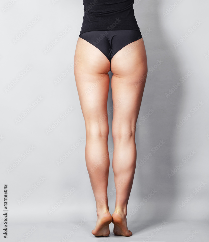 Young woman in black panties standing back to camera