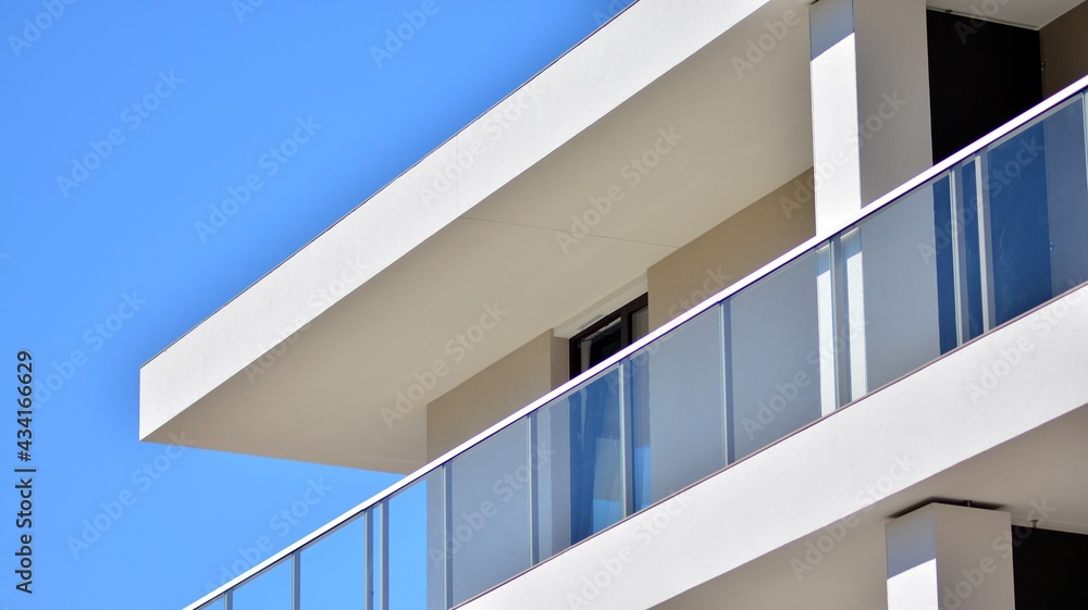 Fototapeta premium Condominium and apartment building with symmetrical modern architecture. Detail in modern residential flat apartment building exterior. Fragment of new luxury house and home complex. 
