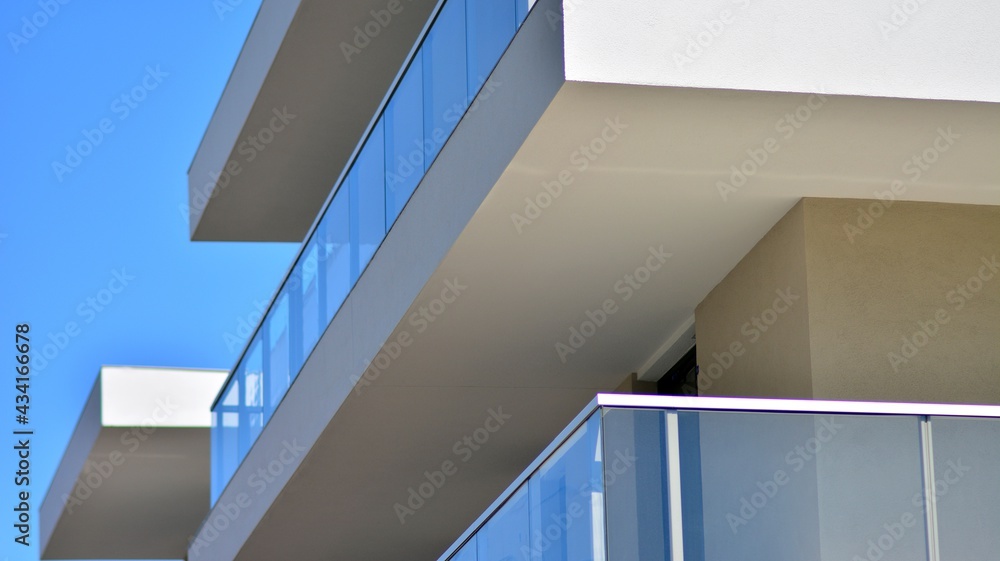 Condominium and apartment building with symmetrical modern architecture. Detail in modern residential flat apartment building exterior. Fragment of new luxury house and home complex. Condominium and apartment building with symmetrical modern architecture. Detail in modern residential flat apartment building exterior. Fragment of new luxury house and home complex.