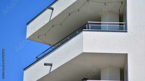 Condominium and apartment building with symmetrical modern architecture. Detail in modern residential flat apartment building exterior. Fragment of new luxury house and home complex.