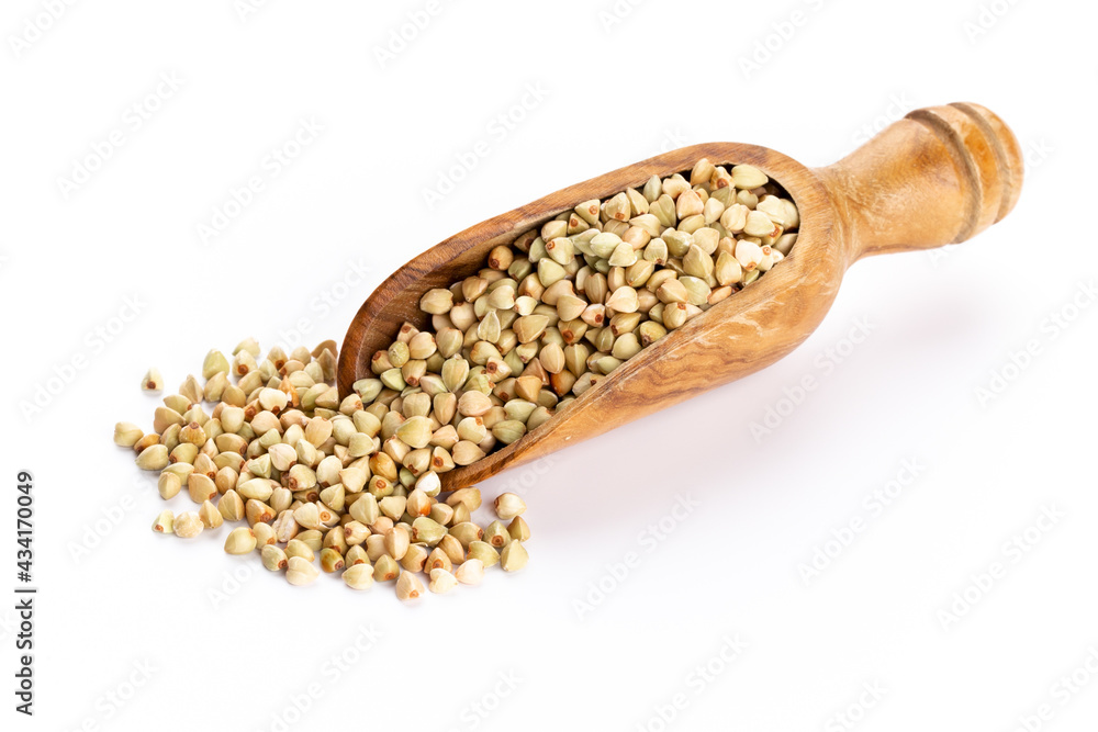 Raw buckwheat and wooden spoon on white background. Raw buckwheat and wooden spoon on white background.