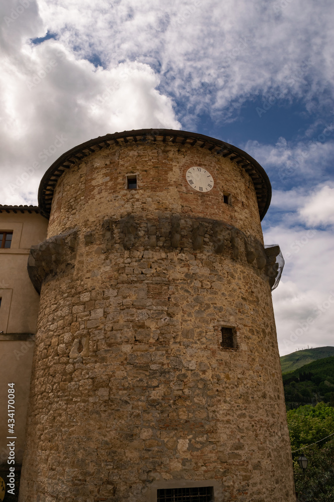 Closeup of an ancient medieval tower with clock, Tuscany, Italy.