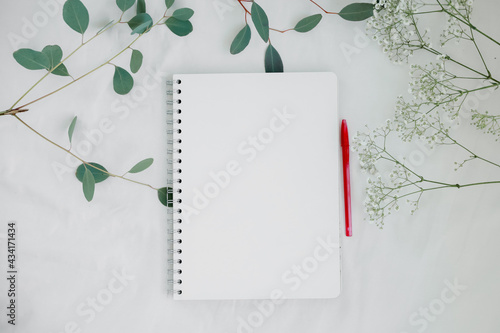 Flat lay. Notebook with space for text, pen and flowers. Planning and organizing concept. 