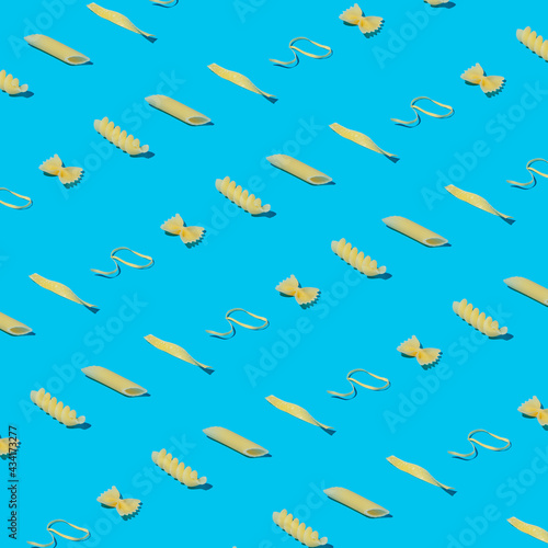 Mixed pasta on a pastel blue background as a pattern. Minimal food concept.