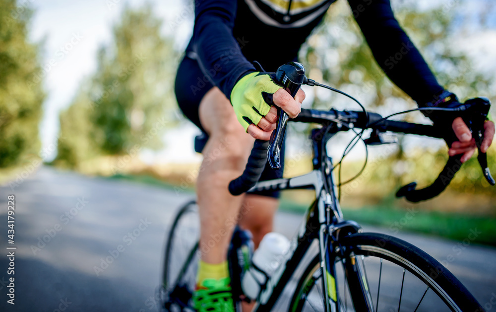 Fototapeta premium Cyclist riding a bicycle, close up photo. Sport and recreation concept