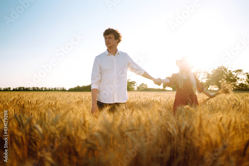 Loving couple in the in a wheat field. Enjoying time together. The concept of youth, love and lifestyle.