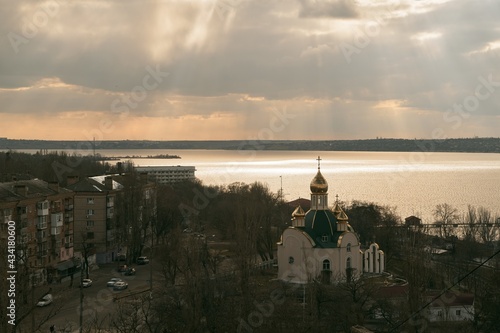 the church with golden domes. Dome of the church reflecting floating sky. Aerial image of the Eastern Orthodox Church on the river © AlexGo