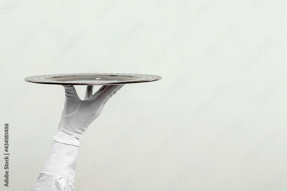 The waiter's hand in white gloves holds a silver tray. Isolate on a light background.