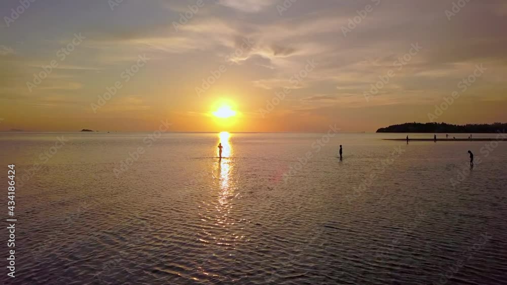 Young Woman Silhouette Walking Alone In the Sea at Beautiful Sunset, Thailand. Young Woman Silhouette Walking Alone In the Sea at Beautiful Sunset, Thailand.