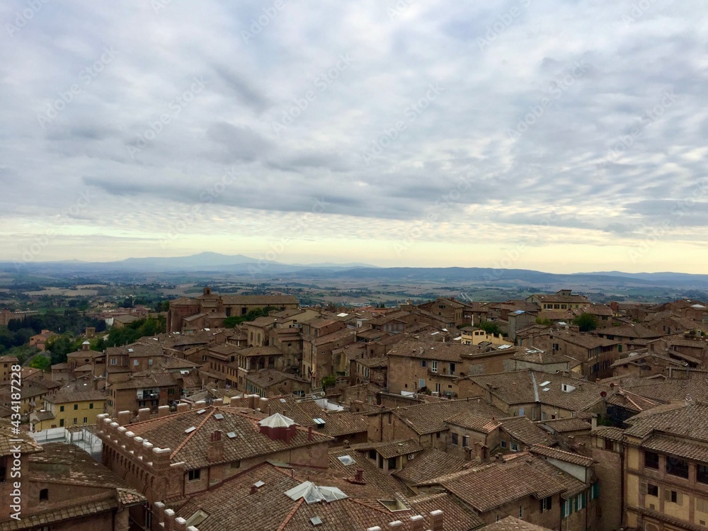SIENA, ITALY. Panorama view of Siena from Cathedral. Evening, cloudy sky, Tuscany hills on a background, tile rooftop, medieval town. Date of photo is 28.09.2015