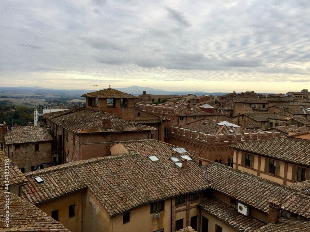 Fototapeta premium SIENA, ITALY. Panorama view of Siena from Cathedral. Evening, cloudy sky, Tuscany hills on a background, tile rooftop, medieval town. Date of photo is 28.09.2015