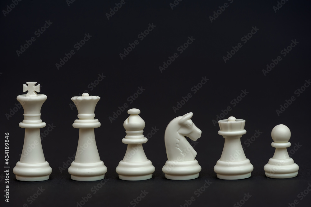 Set of white chess pieces on a black background. Chessmen. Table game. 