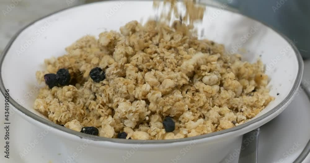 Pouring flax blueberry granola into a bowl slow motion Pouring flax blueberry granola into a bowl slow motion