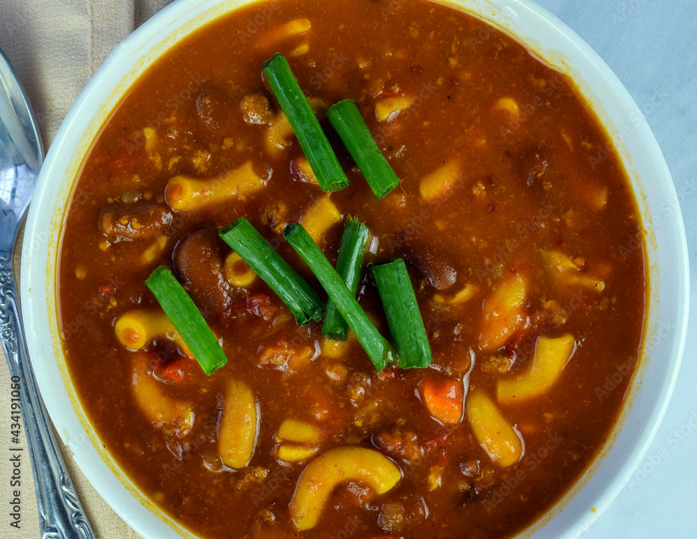 a bowl of chili macaroni with green onions a bowl of chili macaroni with green onions