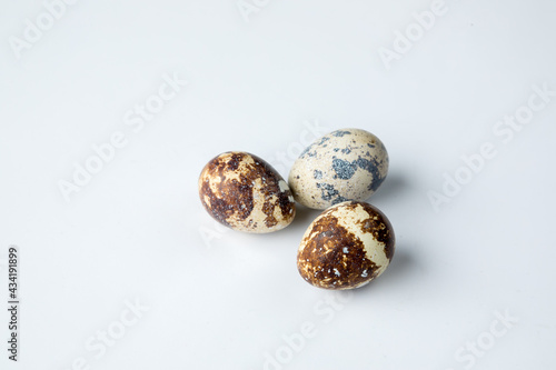 Three quail eggs on a white background
