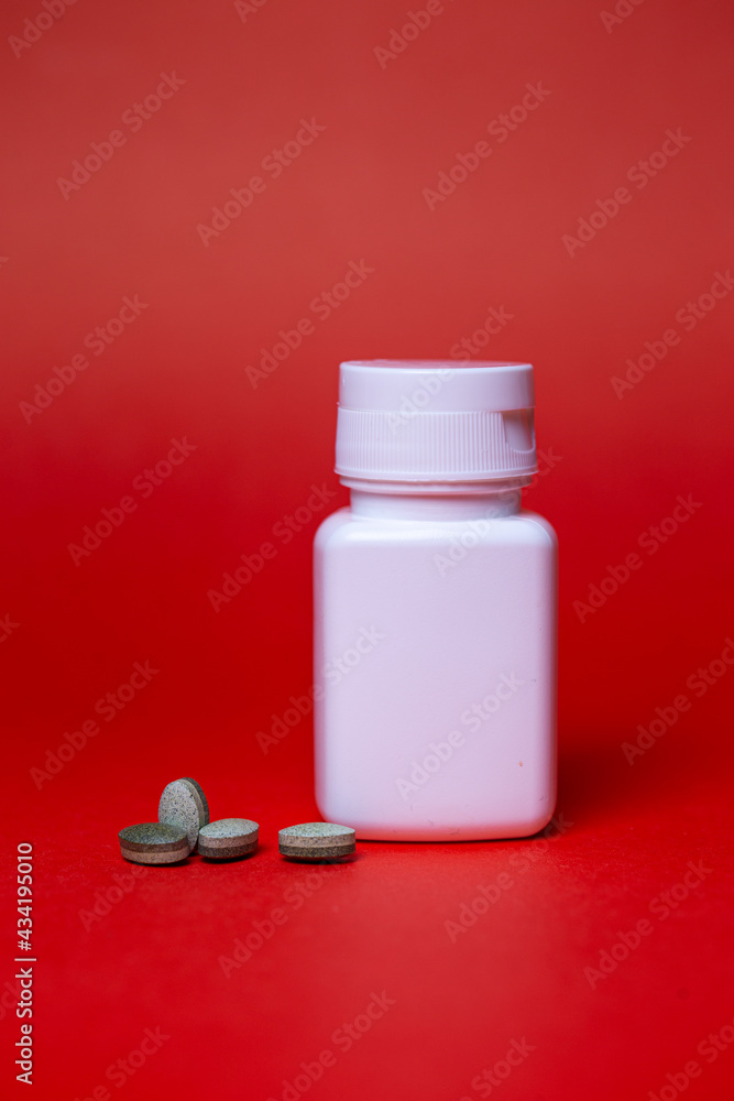 B vitamins and a white jar on a red background B vitamins and a white jar on a red background