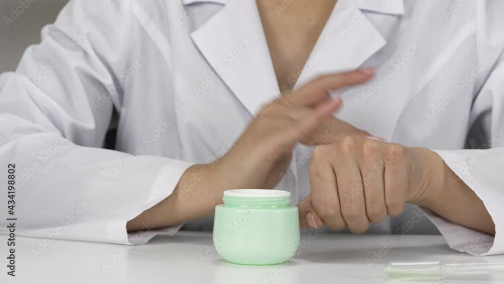 Scientific testing of plant-based microbiome-focused cream in laboratory, cosmetic expert spreading cream on hand, science-based, personalized skincare concept, lab-formulated cosmetics. Close-up Scientific testing of plant-based microbiome-focused cream in laboratory, cosmetic expert spreading cream on hand, science-based, personalized skincare concept, lab-formulated cosmetics. Close-up