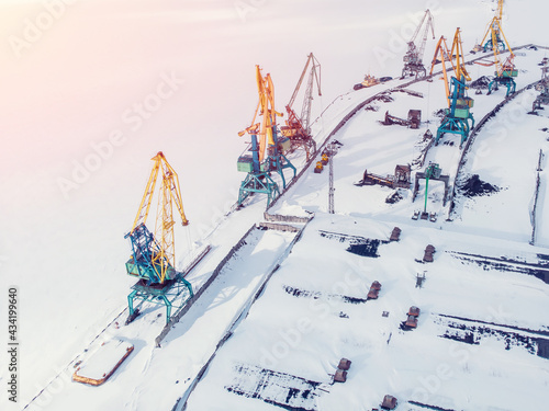 Ice bound frozen port for transshipment of coal from polar mines Container cargo ship loading North Arctic doc, top aerial view