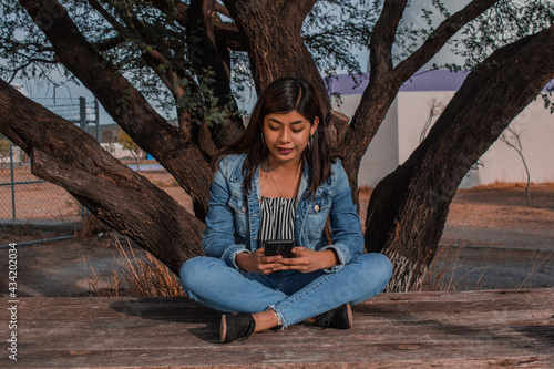 
Woman in denim clothes, reading, listening to music, taking photos photo