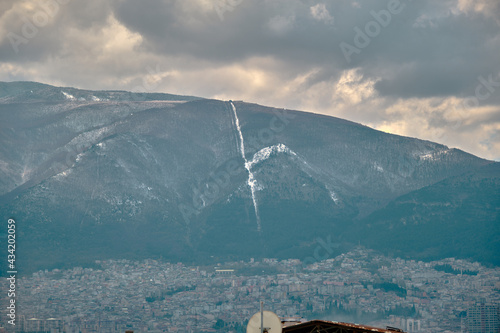 Ulu mountain (uludag) in bursa Turkey during winter and misty and foggy view of mountain from city center and many snow peak of huge moutain. photo