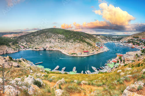 Panoramic view of Balaklava bay with yachts and ruines of Genoese fortress Chembalo in Sevastopol city from the height.