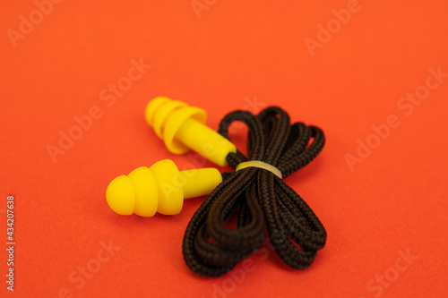 Silicone ear plugs for human ears on red background photo