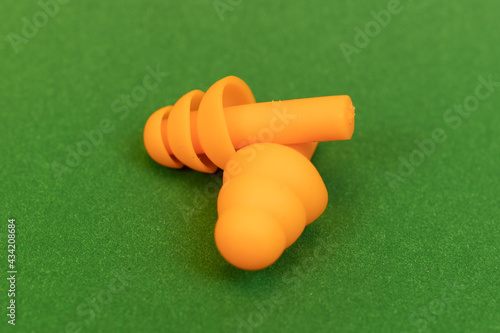 Silicone reusable ear plugs for human ears on green background photo