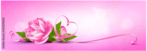 Pink peony bouquet with heart shaped ribbon and bokeh background