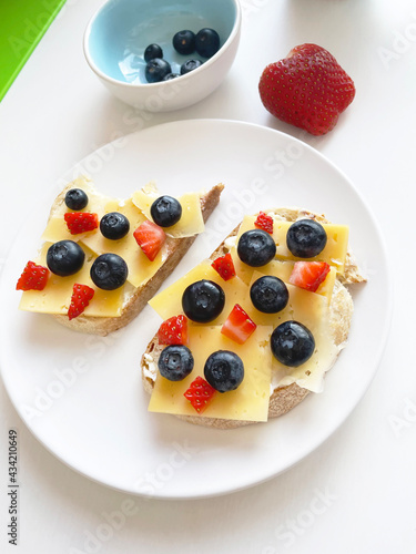 delicious toast for breakfast with buttercream, cheese and strawberries and blueberries. food photos