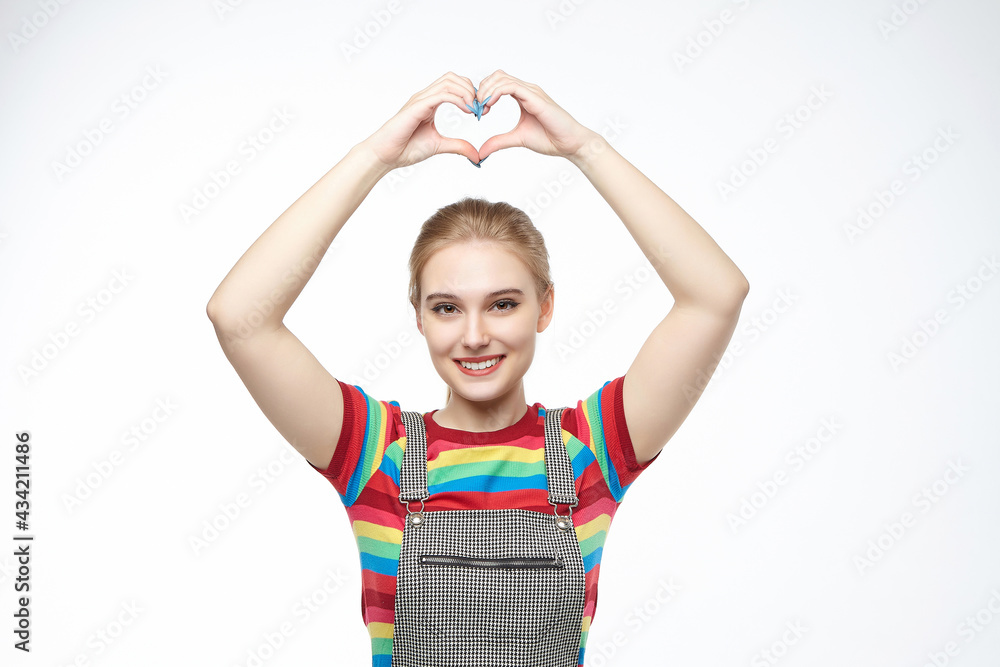 the pretty blonde smiled and folded her hands in the shape of a heart. photo shoot in the studio on a white background the pretty blonde smiled and folded her hands in the shape of a heart. photo shoot in the studio on a white background
