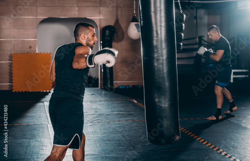 Kickboxer training in the gym kicking the punch bag