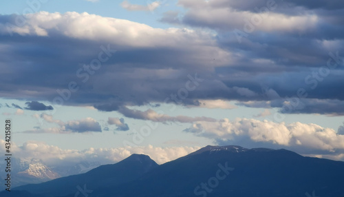 Grandi nuvole sopra le montagne dell   Appennino all   imbrunire in un cielo azzurro primaverile