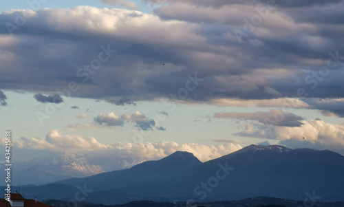 Grandi nuvole sopra le montagne dell   Appennino all   imbrunire in un cielo azzurro primaverile