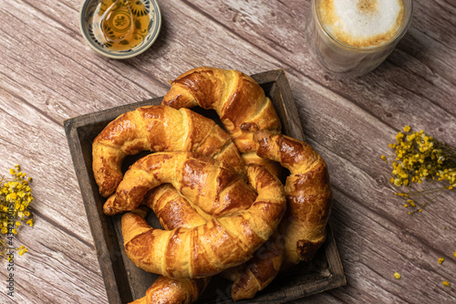 Croissants and cappuccino on wood background photo