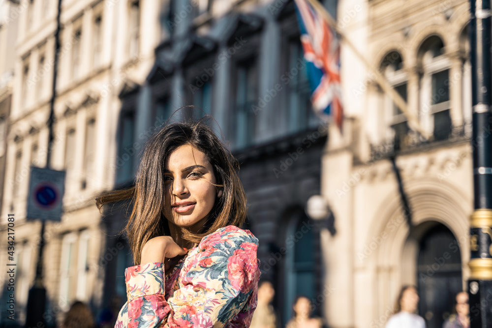 Fototapeta premium Portrait of a beautiful young woman outdoors in the city. Urban landscape. Travel and freelance lifestyle. Youth and beauty