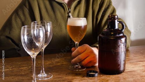 Man serving beer with a growler. Fresh homebrew beer on a glass.