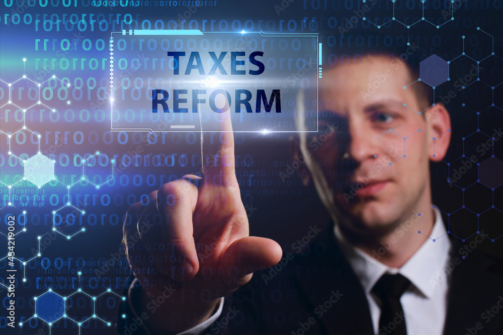 Business, Technology, Internet and network concept. Young businessman working on a virtual screen of the future and sees the inscription: Taxes reform Business, Technology, Internet and network concept. Young businessman working on a virtual screen of the future and sees the inscription: Taxes reform