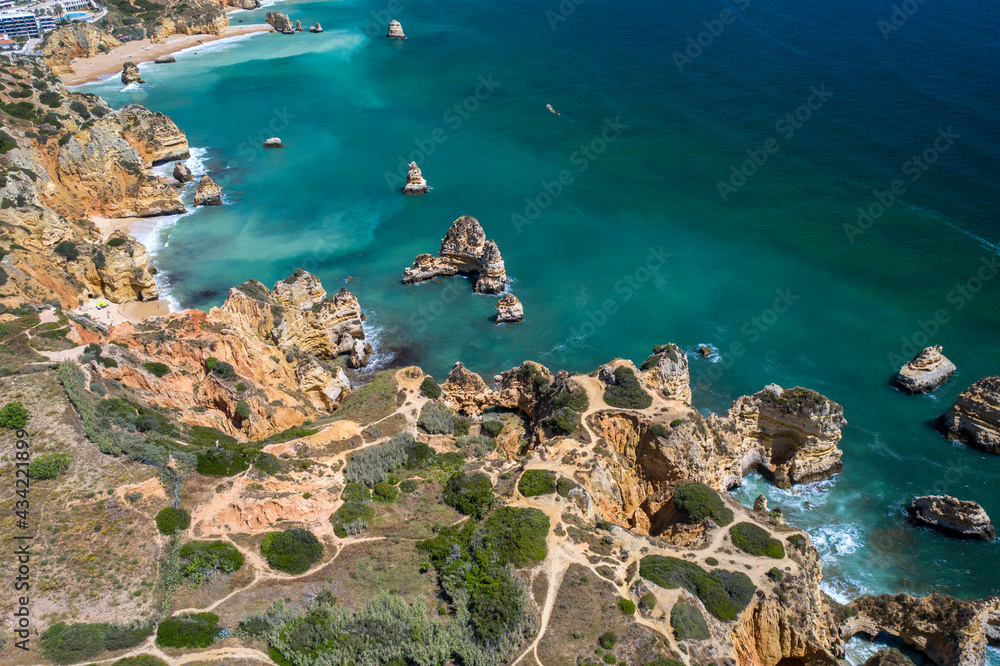 Aerial view of golden coast cliffs of portuguese southern beaches in Lagos City, Algarve, Portugal. Camilo beach and Ponta da Piedade.