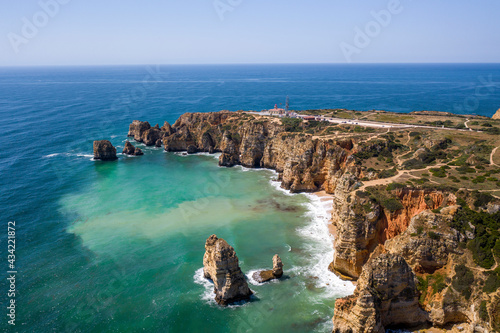 Ponta da Piedade lighthouse. Portuguese southern golden coast cliffs. Aerial view over city of Lagos in Algarve, Portugal.