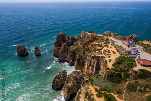 Aerial view of golden coast cliffs of portuguese southern beaches in Lagos City, Algarve, Portugal. Camilo beach and Ponta da Piedade.