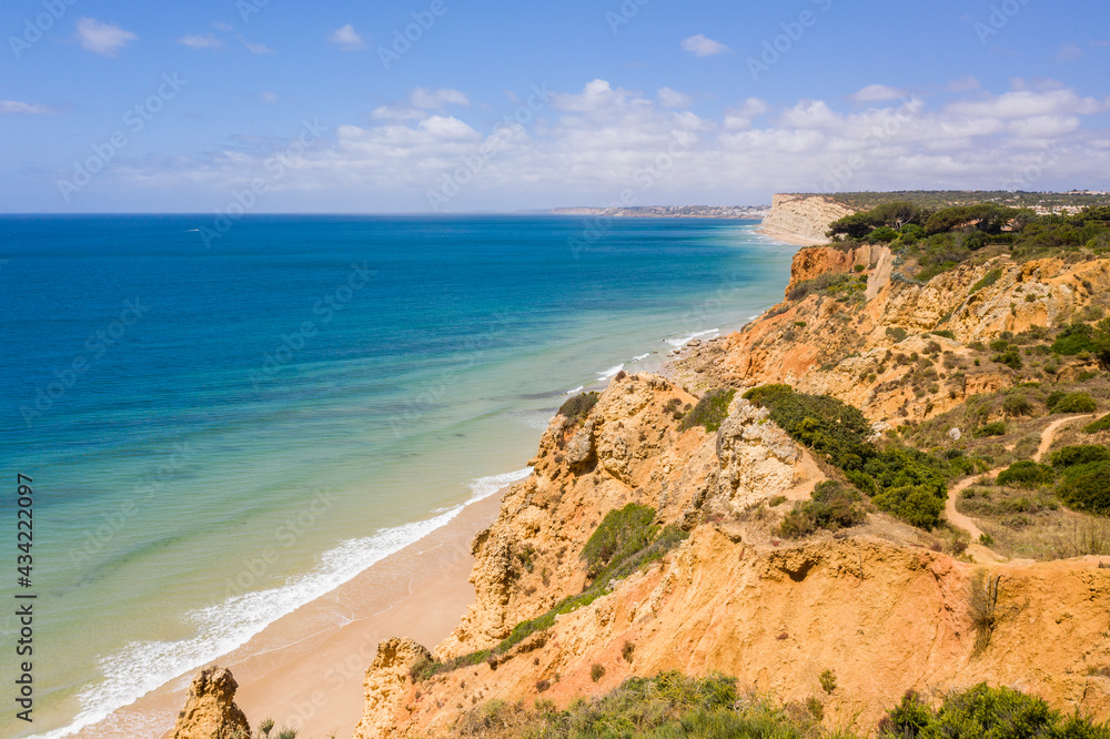 Canavial Beach in Lagos, Algarve - Portugal. Portuguese southern golden coast cliffs. Aerial view with sunny day.