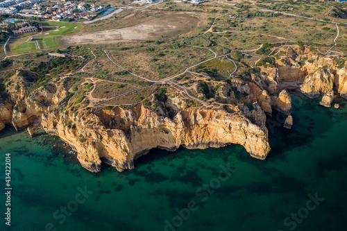 Ponta da Piedade lighthouse. Portuguese southern golden coast cliffs. Aerial view over city of Lagos in Algarve, Portugal.