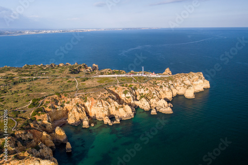 Ponta da Piedade lighthouse. Portuguese southern golden coast cliffs. Aerial view over city of Lagos in Algarve, Portugal.