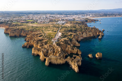 Ponta da Piedade lighthouse. Portuguese southern golden coast cliffs. Aerial view over city of Lagos in Algarve, Portugal.