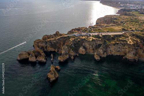 Ponta da Piedade lighthouse. Portuguese southern golden coast cliffs. Aerial view over city of Lagos in Algarve, Portugal.