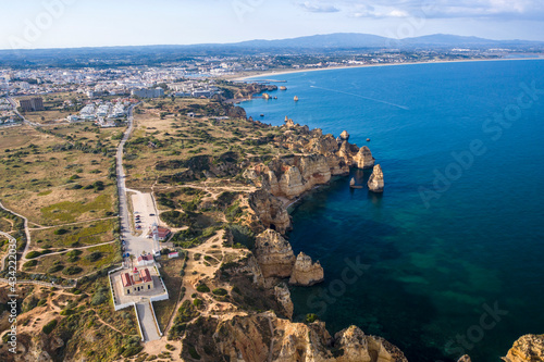 Ponta da Piedade lighthouse. Portuguese southern golden coast cliffs. Aerial view over city of Lagos in Algarve, Portugal.