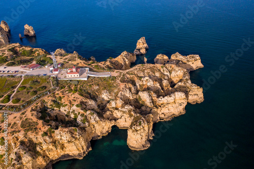 Ponta da Piedade lighthouse. Portuguese southern golden coast cliffs. Aerial view over city of Lagos in Algarve, Portugal.